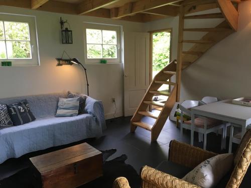 ein Wohnzimmer mit einem Sofa und einer Holztreppe in der Unterkunft Holiday home Vossennest in Veere