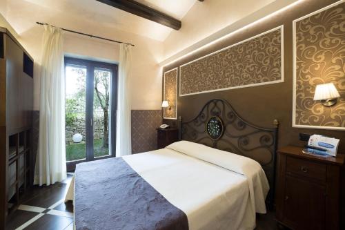 a bedroom with a white bed and a window at Agriturismo Il Granaio Hotel & SPA in Modica