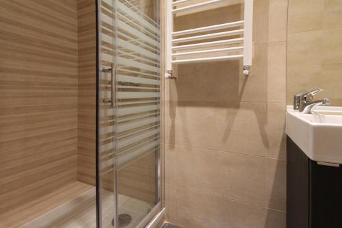 a shower with a glass door next to a sink at Apartamentos Dali Madrid in Madrid