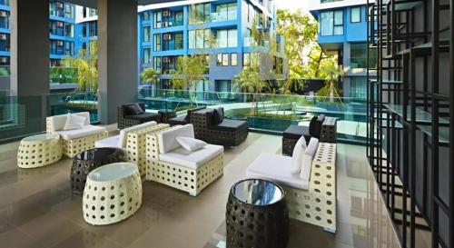 hol z kanapami i stołami w budynku w obiekcie Acqua Apartment w mieście Jomtien Beach