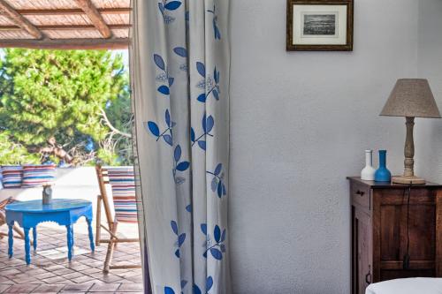 una stanza con tavolo e tenda con fiori blu di Hotel Mercanti di Mare a Santa Marina Salina