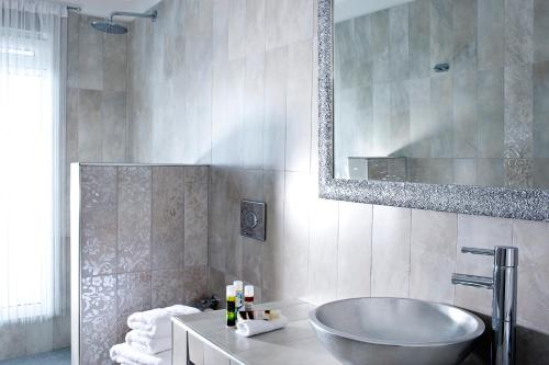 łazienka z wanną, umywalką i lustrem w obiekcie Asteras Villas w Firze