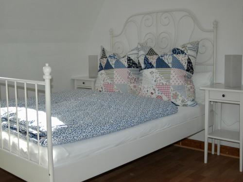 ein weißes Bett mit Kissen darauf im Schlafzimmer in der Unterkunft Ferienhaus Am Keschtebaum in Sasbachwalden