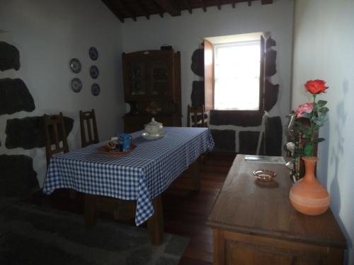 a dining room with a table and a window at Casa da Madrinha Graciosa in Trás dos Pomares