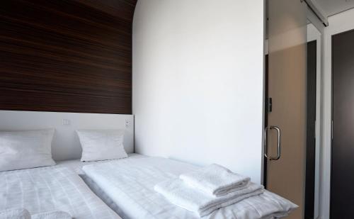 a bedroom with a bed with white sheets and pillows at Steel House Copenhagen in Copenhagen