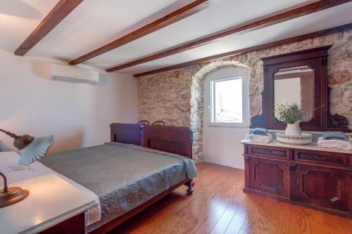 1 dormitorio con cama, tocador y espejo en Hilltop Apartment Vidovici, en Vidović