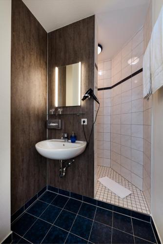 a bathroom with a sink and a mirror at Hotel & Gasthaus Nagel GmbH in Südlohn