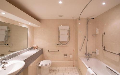 a bathroom with a sink and a toilet and a bath tub at Citrus Hotel Coventry South by Compass Hospitality in Coventry
