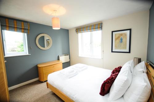 a bedroom with a white bed and two windows at Orchard Gate Apartments from Your Stay Bristol in Bristol