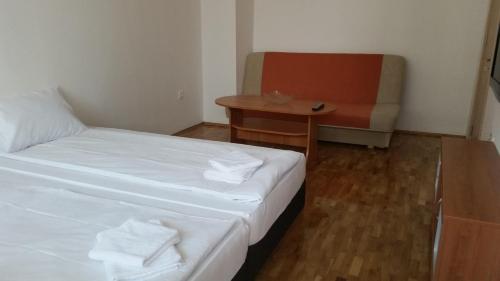 a room with a bed and a table and a chair at 4U Apartment - Gurko in Burgas City