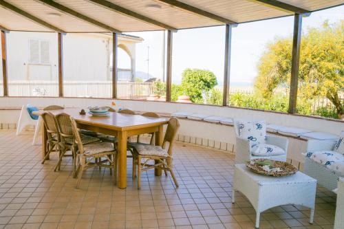 a porch with a table and chairs on a patio at Villa Giglio Marino in Paestum
