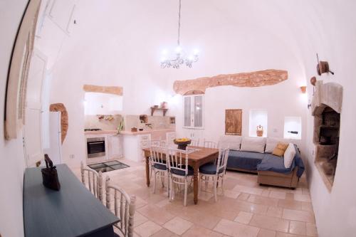 a kitchen and living room with a table and a couch at Petrarussa Dimora Storica in Morciano di Leuca