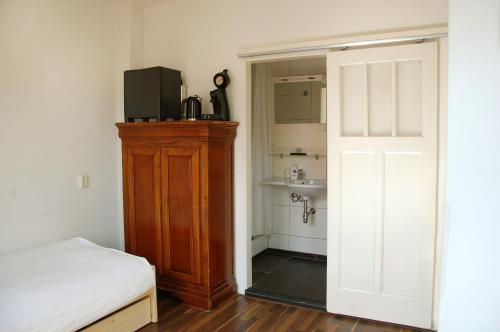 Schlafzimmer mit einem Bett, einer Kommode und einem Spiegel in der Unterkunft Ensche-Day Inn in Enschede