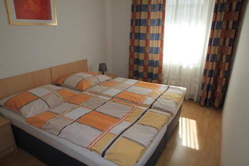 1 cama grande en un dormitorio con ventana en Appartementhaus Anna, en Linz
