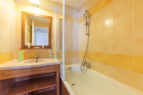 a bathroom with a sink and a tub and a mirror at Résidence Pierre & Vacances Pyrenees 2000 Le Séquoia in Bolquere Pyrenees 2000