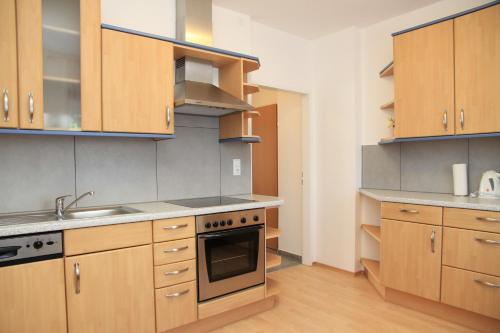 a kitchen with wooden cabinets and a stove top oven at Appartementhaus Anna in Linz