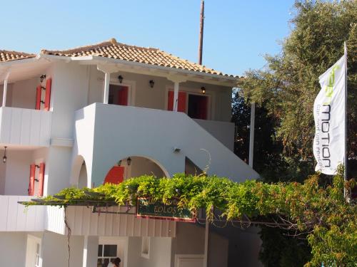 a white building with a sign in front of it at Eolos Apartments with Private Parking in Agios Nikitas