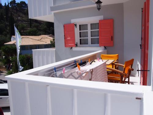 a kitchen with red cabinets and a table with chairs at Eolos Apartments with Private Parking in Agios Nikitas