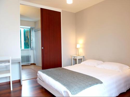 a bedroom with a white bed and a red door at Hôtel Restaurant Aldaburua in Larressore