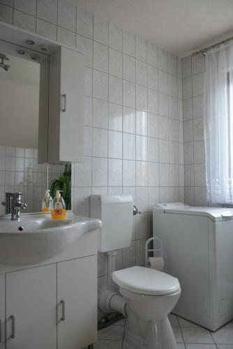 a white bathroom with a toilet and a sink at Ferienwohnung Starke in Gablenz