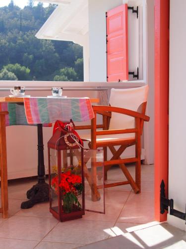 a table and a chair in a room with a window at Eolos Apartments with Private Parking in Agios Nikitas