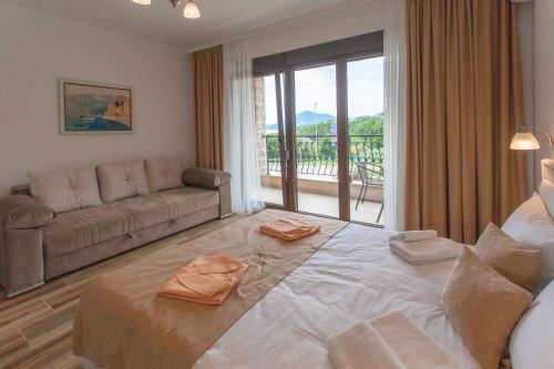 a living room with a large bed and a couch at Rosmarino in Sveti Stefan