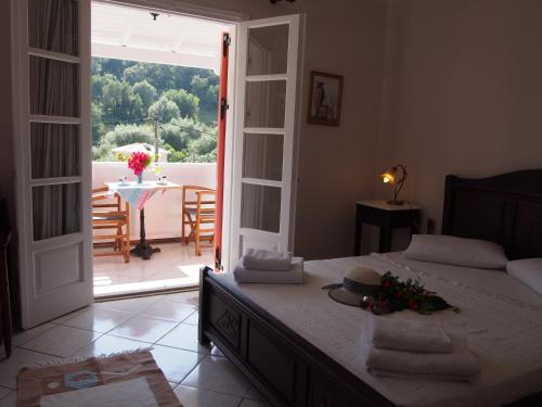 a bedroom with a bed with a view of a patio at Eolos Apartments with Private Parking in Agios Nikitas