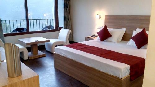 a hotel room with a bed and a balcony at Hotel Emerald Valley in Chail