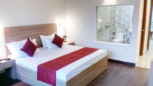 a bedroom with a large bed with a window at Hotel Emerald Valley in Chail
