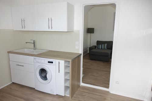 a kitchen with a washing machine and a sink at Appartements Le Cru Colbert in Beaune