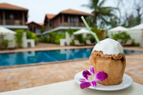 een cupcake op een bord naast een zwembad bij Bambu Hotel in Battambang