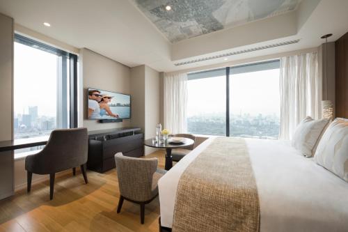 a bedroom with a large bed and a large window at Ascott Marunouchi Tokyo in Tokyo