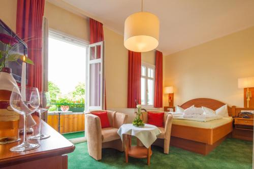 バート・ハルツブルクにあるHotel Victoriaのベッドとテーブルが備わるホテルルームです。