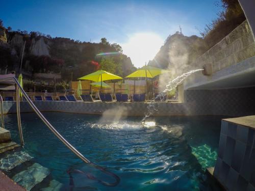 a swimming pool filled with lots of colorful umbrellas at Hotel Regina del Mare in Ischia