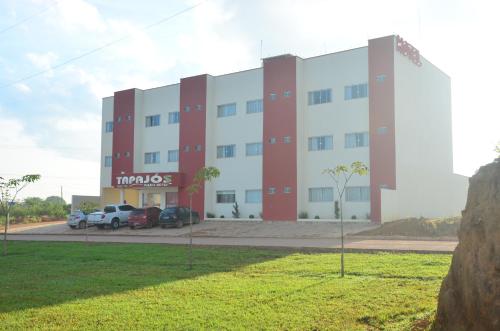 a large building with cars parked in front of it at Tapajos Palace Hotel in Novo Progresso