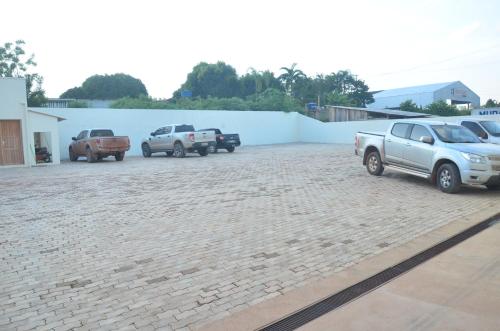 a parking lot with cars parked next to a white wall at Tapajos Palace Hotel in Novo Progresso
