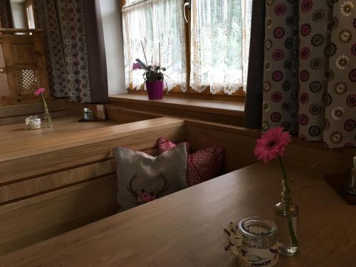 a vase with a flower on a table in a room at Gasthof Botenwirt in Faistenau