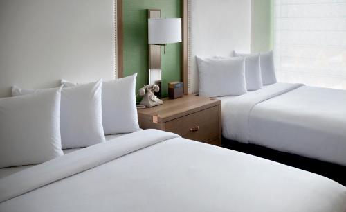 two beds with white pillows in a hotel room at Hayes Street Hotel Nashville in Nashville