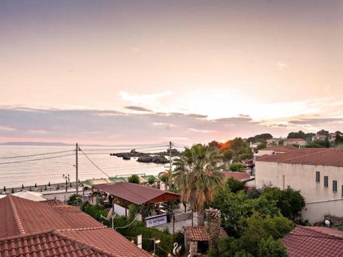 a plane flying over a town with houses and the ocean at Potamaki Studios & Apartments in Stoupa