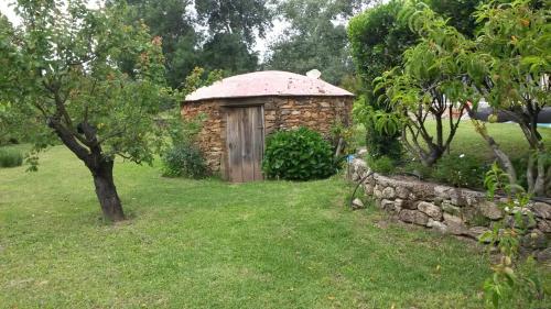 a small stone building in a yard with a tree at Los Montejos & Spa in Valverde del Fresno