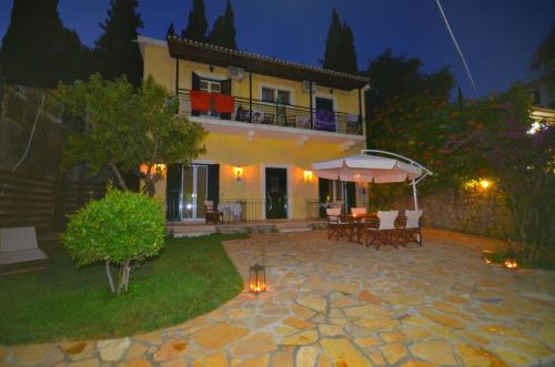 a house with a patio in front of it at night at Taxi Driver Apartments in Paleokastritsa