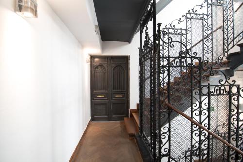 a hallway with a black door and a staircase at Petit Palace Puerta del Sol in Madrid