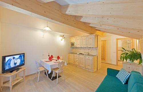 a living room with a table and a kitchen at Cesa Melester in Campitello di Fassa
