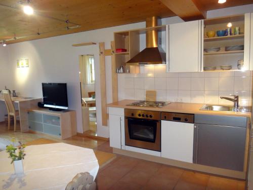 cocina con fregadero y fogones horno superior en Gästehaus Appartements Egender, en Bezau