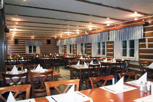 a restaurant with wooden tables and chairs in a room at Horska chata Svetlanka in Rokytnice nad Jizerou