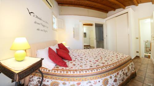チェファルにあるCaracciolo Loungeのベッドルーム1室(赤い枕とテーブル付きのベッド1台付)