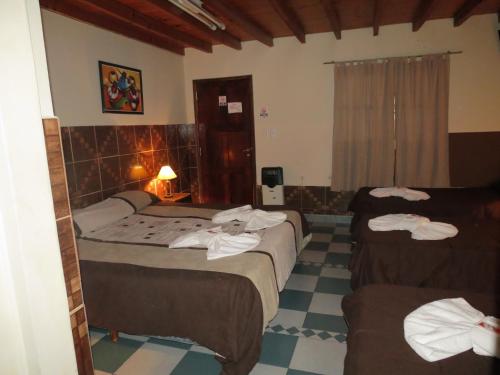 a hotel room with two beds and a checkered floor at Hotel Pachá in Salta