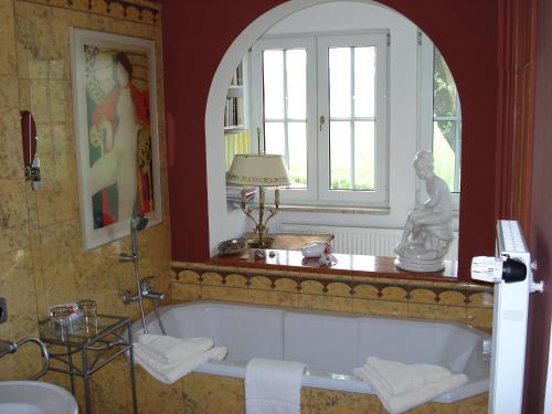 ein Bad mit einer Badewanne und einem Fenster in der Unterkunft Hotel-Restaurant Bergmühle in Neudrossenfeld