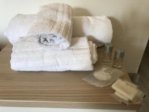 Una mesa de madera con toallas y dos botellas de jabón. en Raxul Room, en Sestu