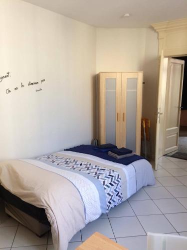 Bett in einem Zimmer mit einem Wandschreiben in der Unterkunft Gite de la Princerie in Verdun-sur-Meuse